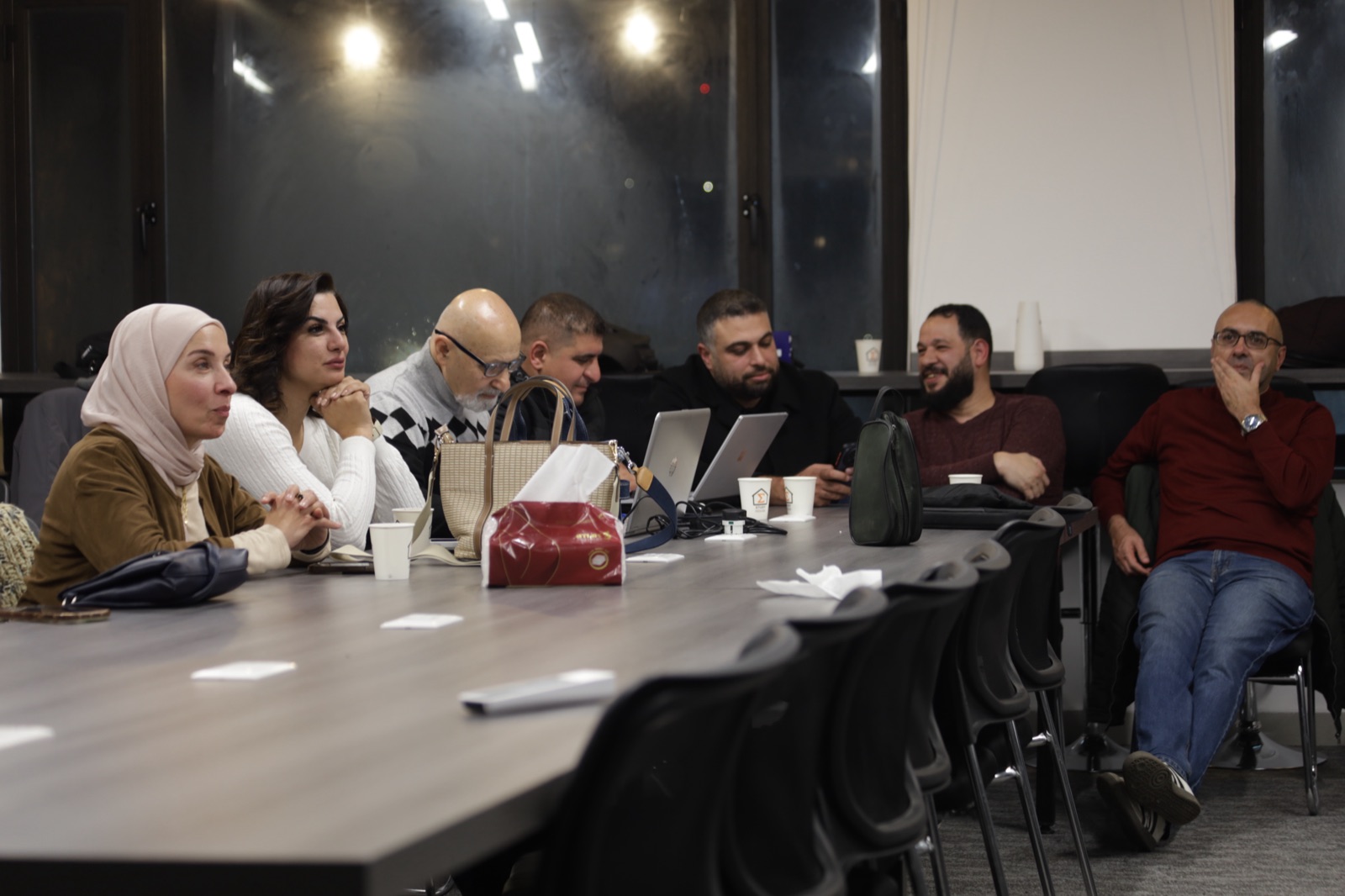 Sigma Study House session — attendees taking notes at a shared table with laptops, Amman, March 2026.